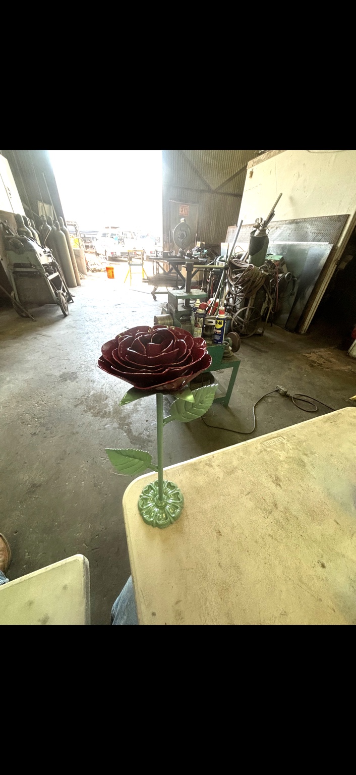 Painted metal rose with red petals and green leaves